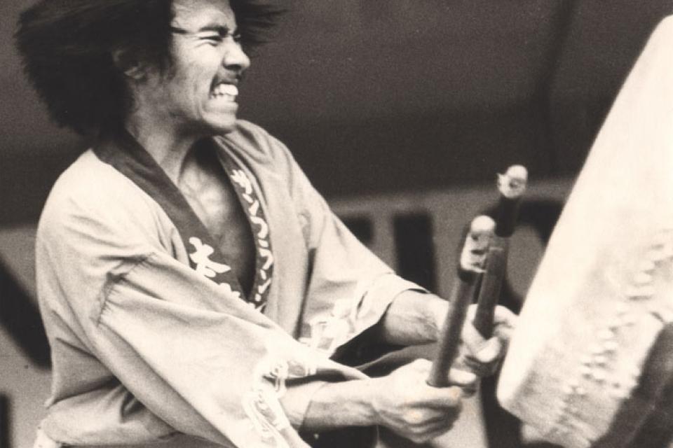 Kenny Endo fiercely beats a big drum